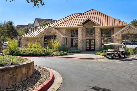 a clubhouse with a golf cart parked in front of a building